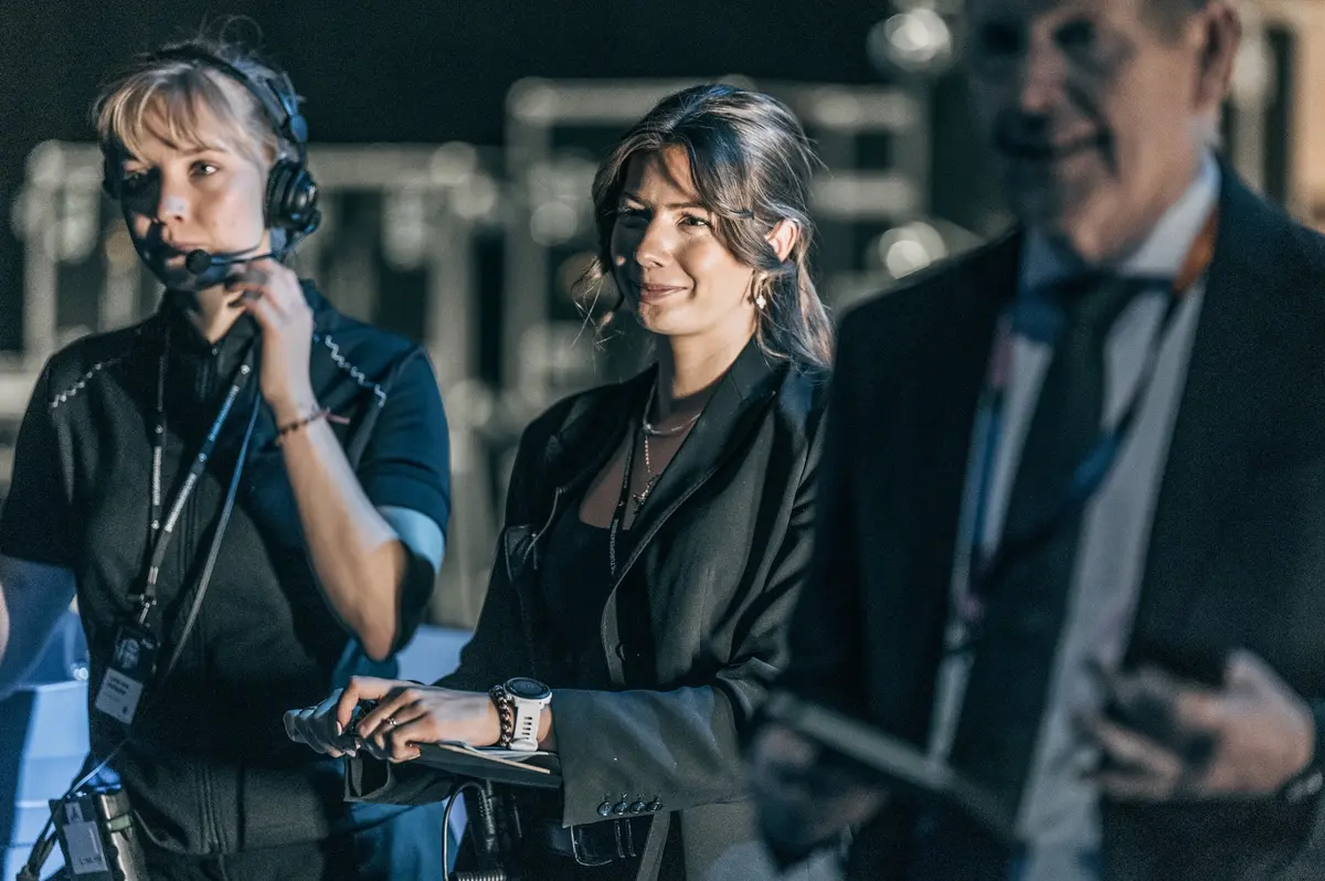Backstage: medarbeider med headset i samtale bak scenen
