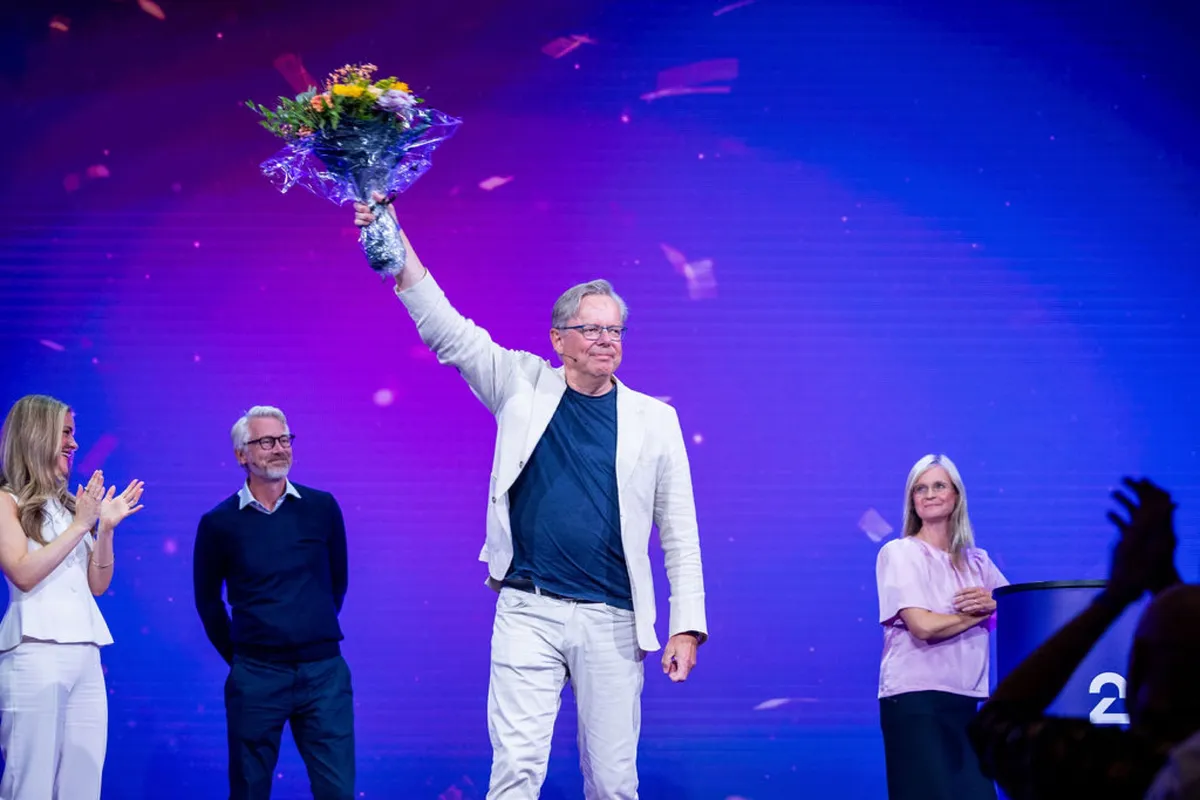 Prisvinner holder blomsterbukett i været på scenen